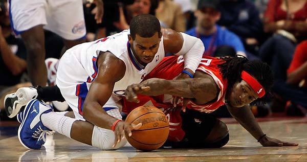 Clippers point guard Chris Paul and Rockets point guard Courtney Fortson go to the court in chase of a loose ball during the second quarter Saturday afternoon at Staples Center.