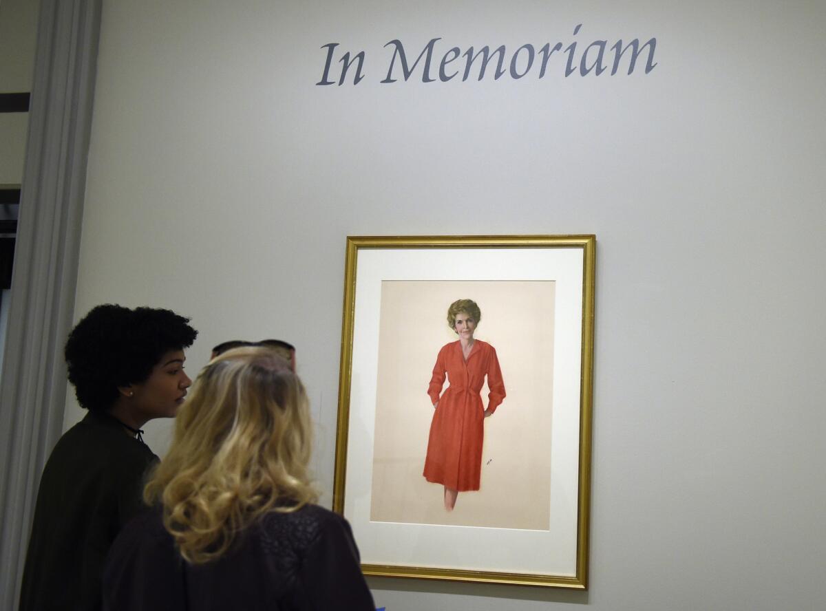 Visitors at the National Portrait Gallery in Washington look at a portrait of former first lady Nancy Reagan.