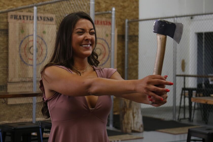 Blind dater Carli lines up her throw while playing tic-tac-toe with throwing axes at Battle Axe San Diego. Carli won.