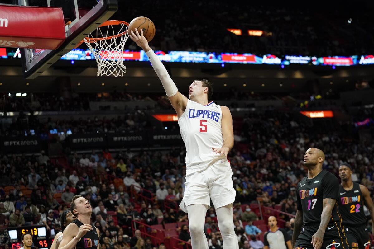 The Clippers' Luke Kennard goes to the basket over the Heat's Duncan Robinson, left, and P.J. Tucker (17).