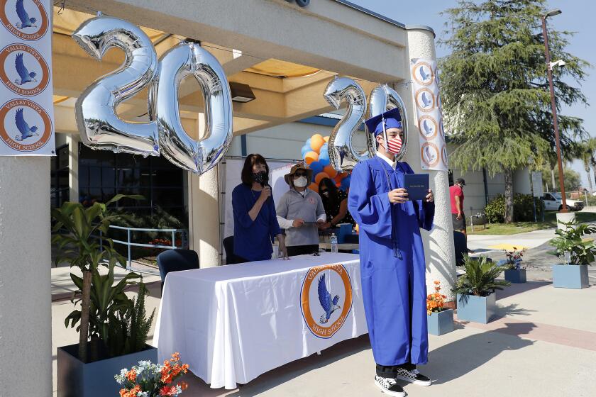 Chance Conant poses with his diploma for family members during a drive-thru graduation ceremony for Valley Vista High School in Fountain Valley on Wednesday.