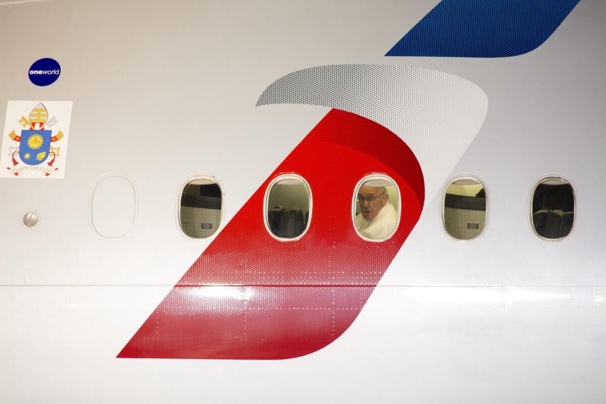 Pope Francis glances from the window of his plane as his flight departs from Philadelphia.