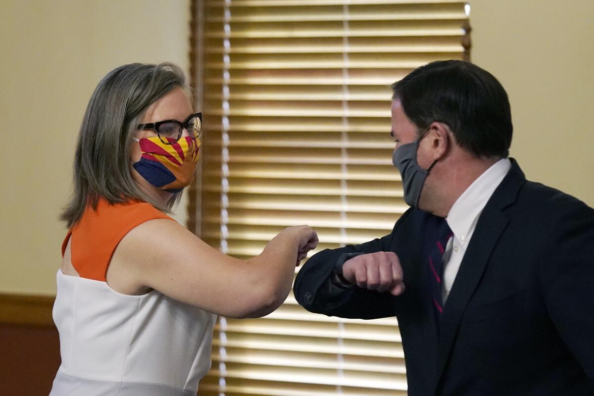Arizona Secretary of State Katie Hobbs and Arizona Gov. Doug Ducey bump elbows