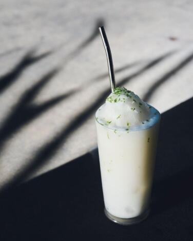 El Coco margarita from Damian, a tall white frosty drink with a straw.