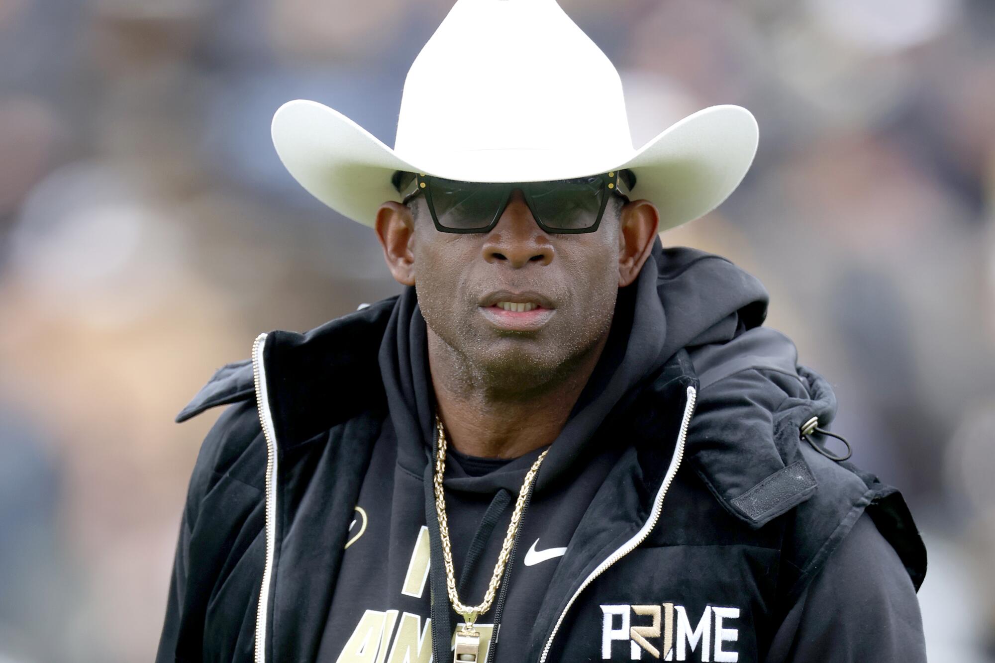 Colorado coach Deion Sanders watches as his team warms before playing its spring game