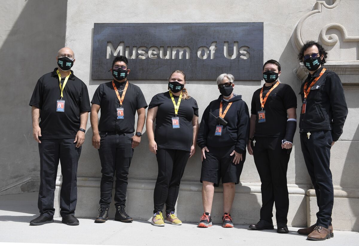 The new visitor experience team outside the new sign for the Museum of Us.  