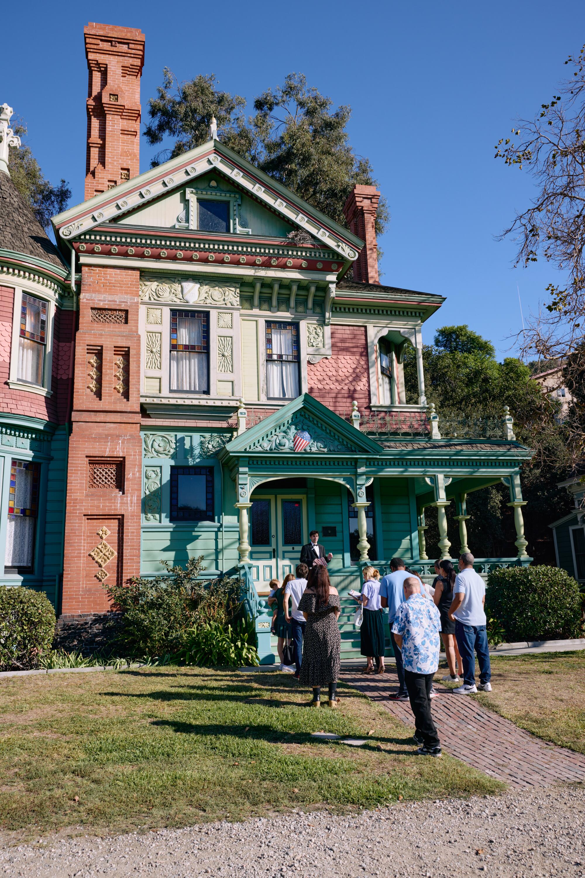 Guests congregate outside of one of the Victorian buildings that comprise L.A.'s Heritage Square Museum.