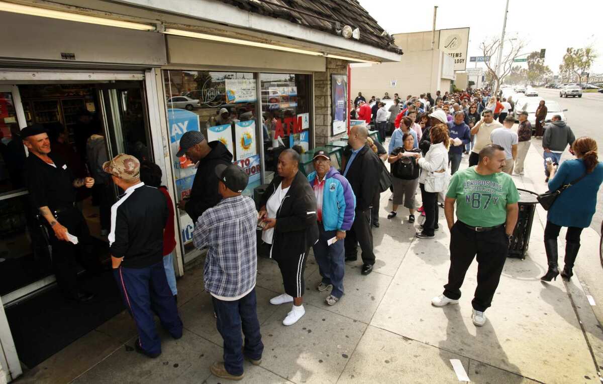 A security guard monitors the line at Bluebird Liquor in Hawthorne.