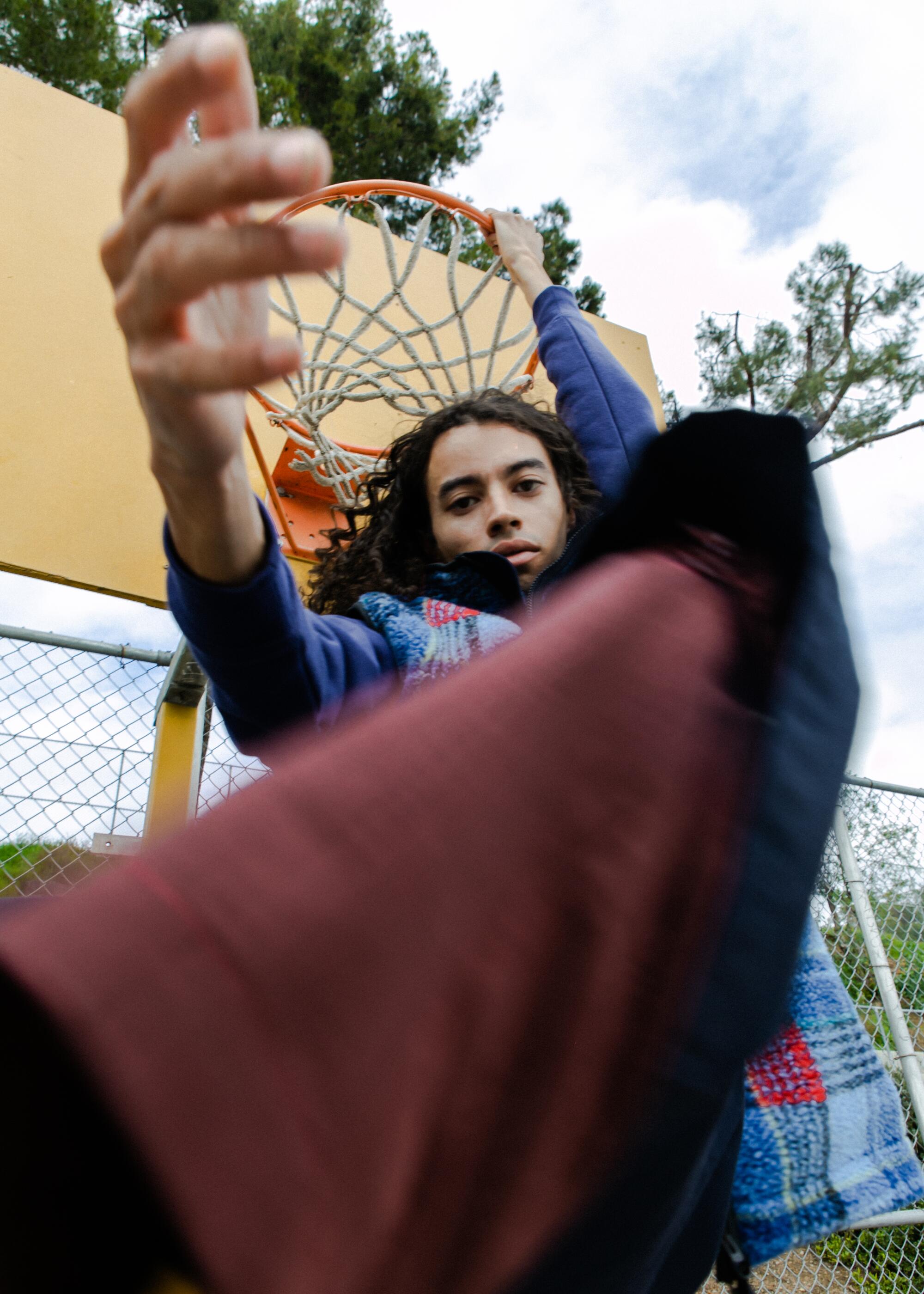 Photograph of model holding basketball rim in Lincoln Heights.