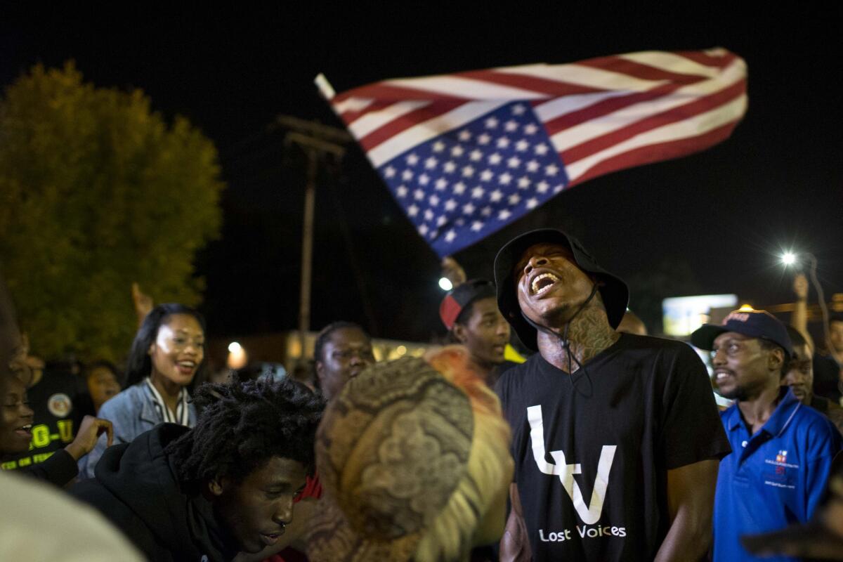 Protesters gather in front of the Police Department Tuesday in Ferguson, Mo. Protests continued in the St. Louis suburb after the fatal police shooting of Michael Brown.
