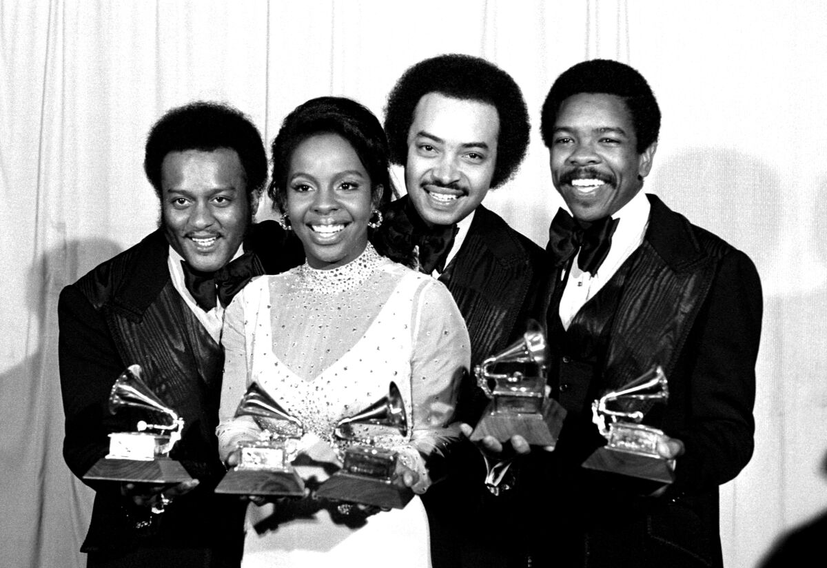 A singing group of three men and one woman hold Grammy Awards they just won, in 1974.