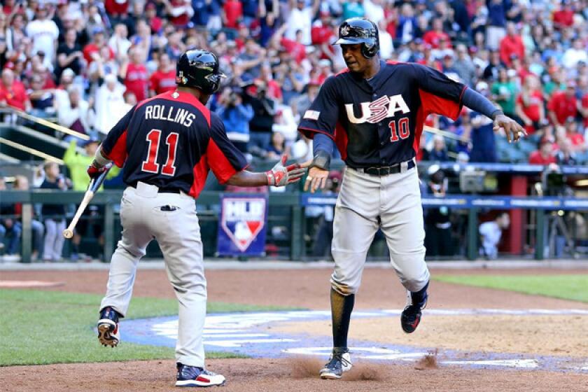 Adam Jones (10) of USA celebrates with Jimmy Rollins (11) after scoring a run against Canada.