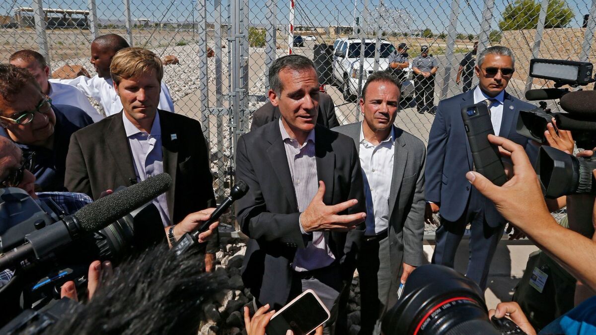 Los Angeles Mayor Eric Garcetti, center, in Tornillo, Texas, last month. The Times has gone to court in an attempt to obtain records related to Garcetti's security costs when he travels out of state.