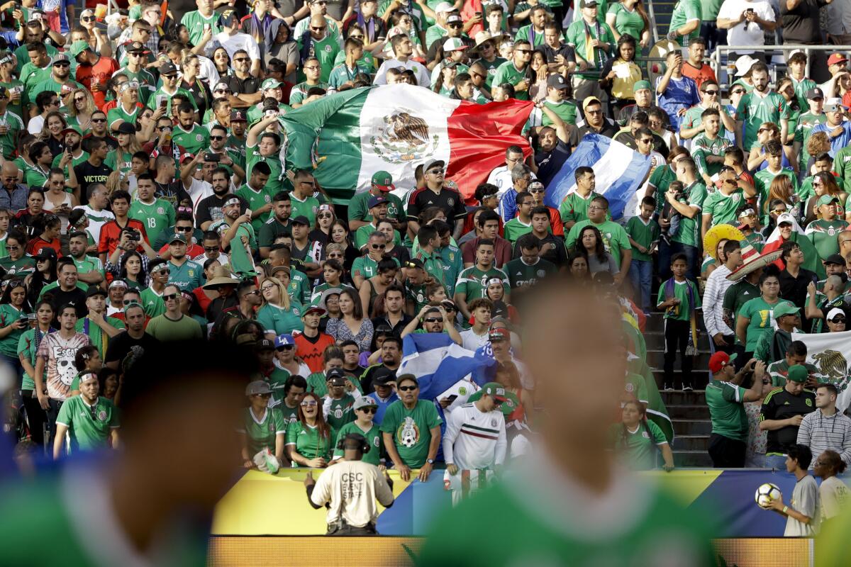 Mexico fans hold a flag before El Salvador and Mexico play during a CONCACAF Gold Cup soccer match in San Diego, Sunday, July 9, 2017. (AP Photo/Gregory Bull)