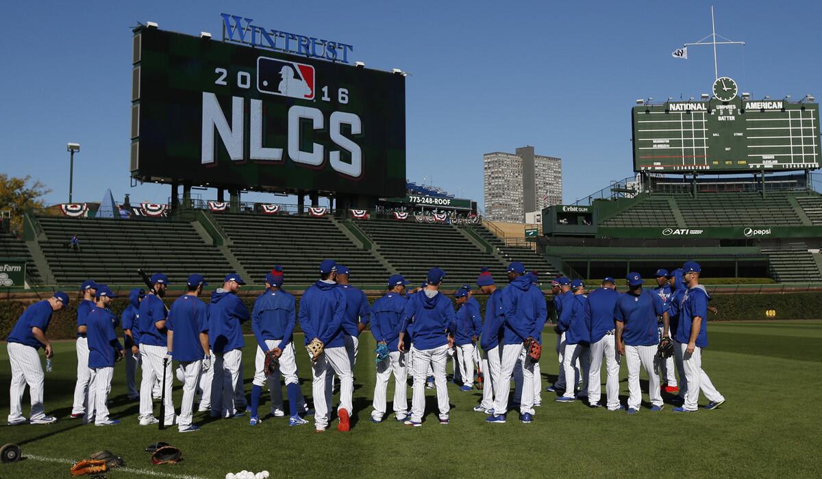 Chicago Cubs players stand on the the field during a team workout in preparation for Saturday's Game 1 of the NLCS.