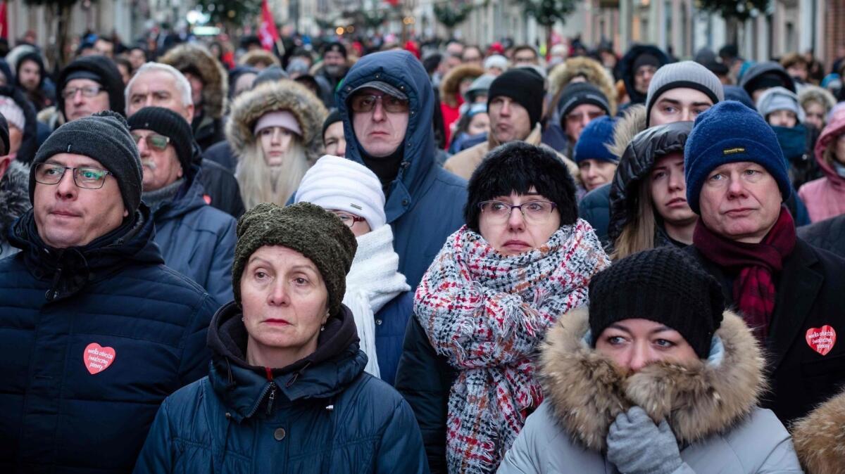 People watch the funeral of the slain mayor of Gdansk, Pawel Adamowicz, on a giant screen Jan. 19 outside St Mary's Basilica in Gdansk, Poland.