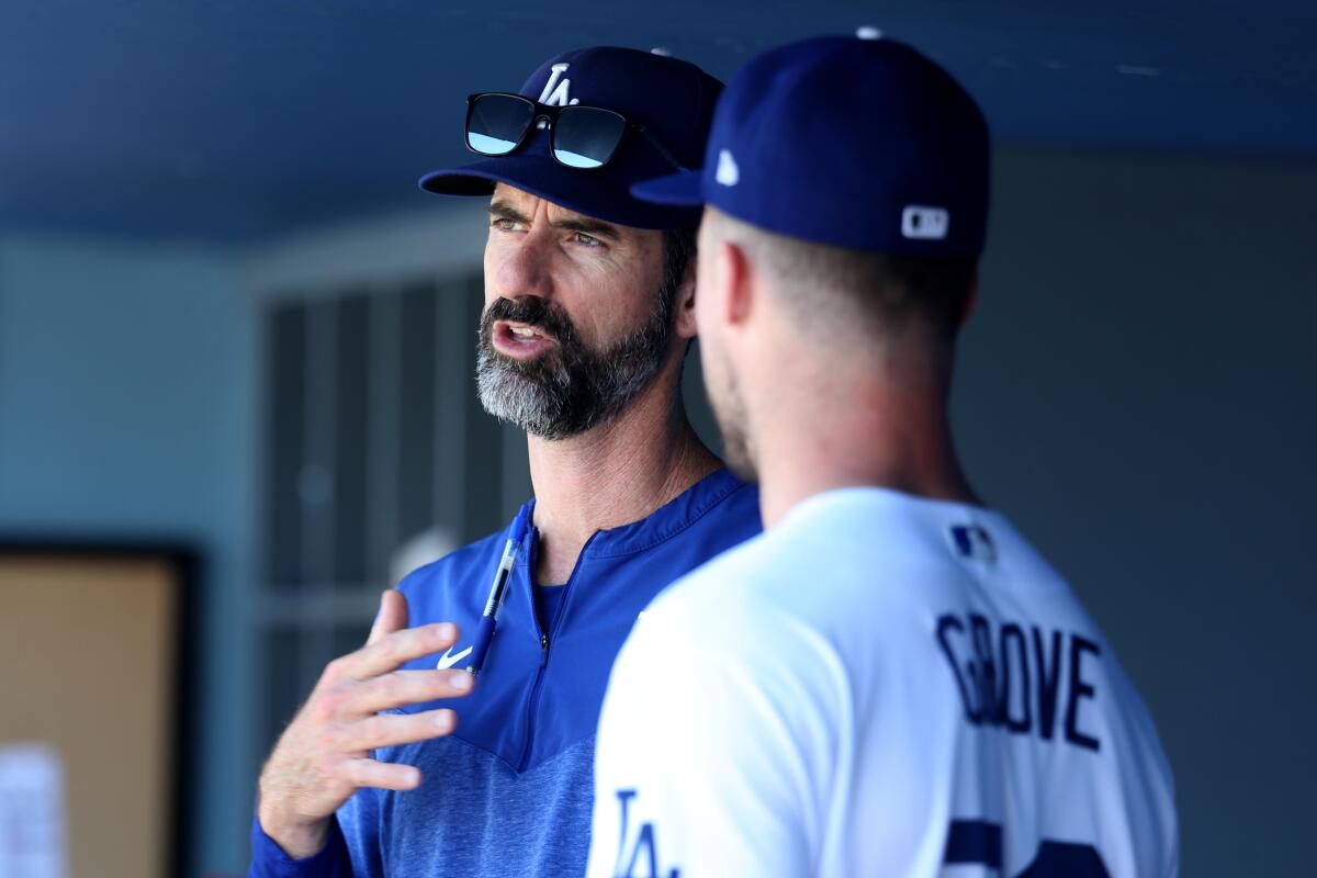 Dodgers pitching coach Mark Prior talks with pitcher Michael Grove in the dugout during the eighth inning Sunday.
