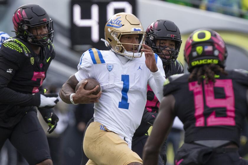 UCLA 's Dorian Thompson-Robinson (1) runs against the Oregon defense