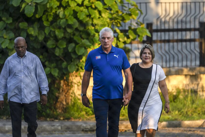 Cuba's President Miguel Diaz Canel walks with his wife Lis Cuesta Peraza before casting his vote at a polling station during the new Family Code referendum in Havana, Cuba, Sunday, Sept. 25, 2022. The draft of the new Family Code, which has more than 480 articles, was drawn up by a team of 30 experts, and it is expected to replace the current one that dates from 1975 and has been overtaken by new family structures and social changes. (AP Photo/Ramon Espinosa)