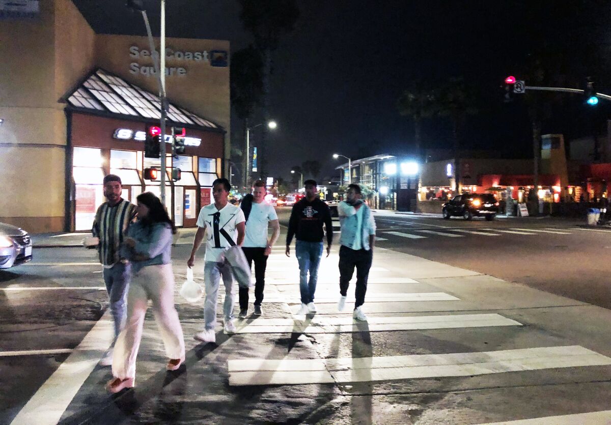 People walk in Pacific Beach without masks Tuesday at 9 p.m.