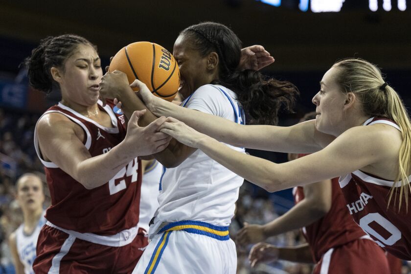 UCLA guard Charisma Osborne, center, battles for the ball against Oklahoma guards Skylar Vann, left, and Aubrey Joens during the first half of a second-round college basketball game in the NCAA Tournament, Monday, March 20, 2023, in Los Angeles, Calif. (AP Photo/Kyusung Gong)