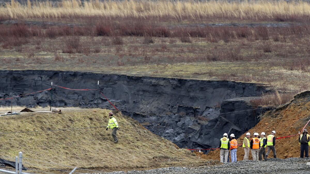 Duke Energy engineers and contractors survey the site of a coal ash spill at the Dan River Power Plant in Eden, N.C., in February.