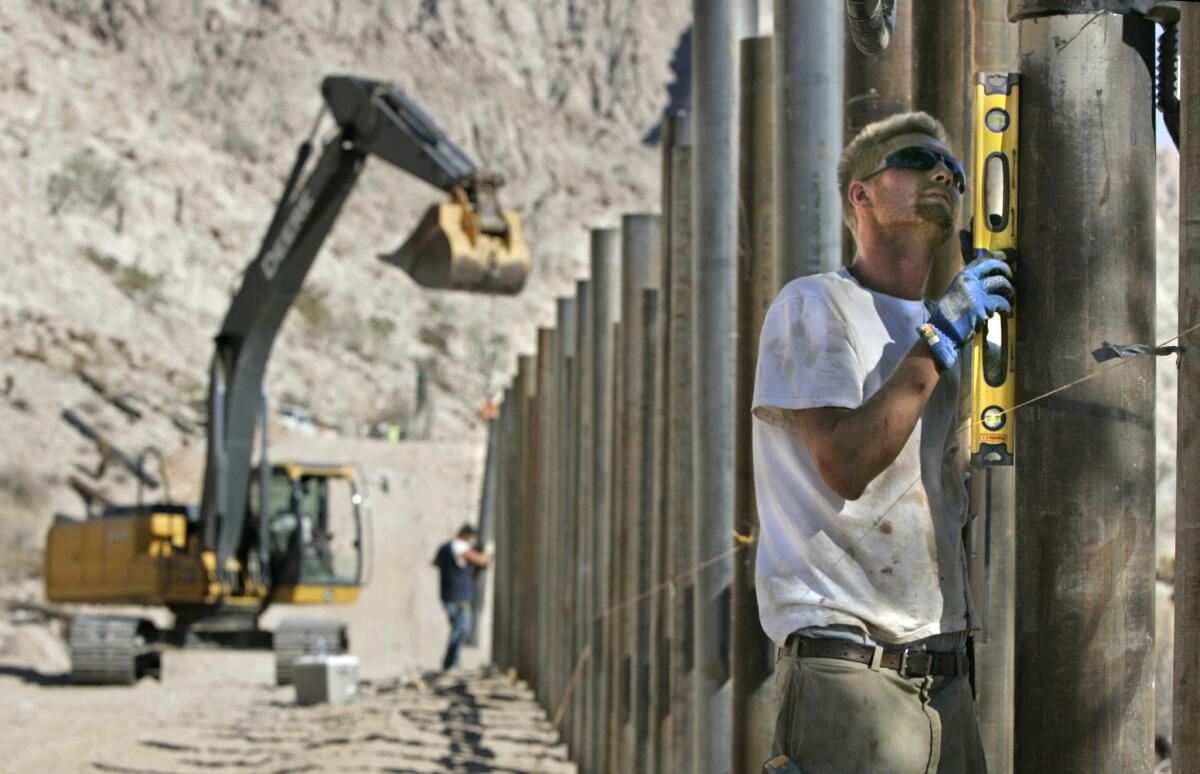 Sept. 19, 2007: Forty miles into the desert east of San Luis, Ariz., Dan Anskate checks the level of a 12-inch-diameter steel fence post. All new fences along the border must be able to withstand a 40-mph impact from a vehicle.