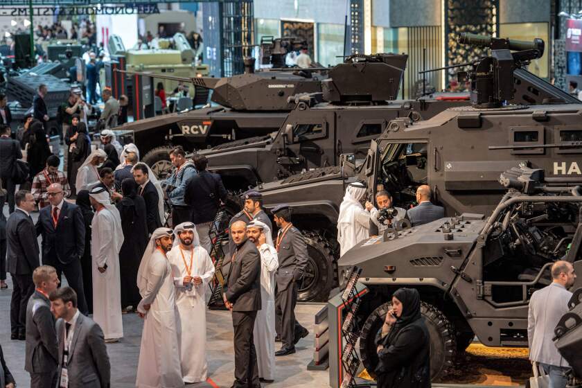 Visitors stand near armoured military vehicles at the EDGE pavilion during the International Defence Exhibtion (IDEX) at the Abu Dhabi International Exhibition Centre on February 20, 2023. (Photo by Ryan LIM / AFP) (Photo by RYAN LIM/AFP via Getty Images)