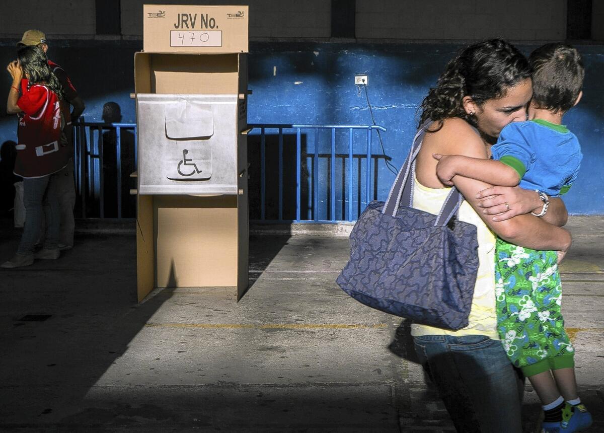 A woman holds her child after voting in El Salvador’s presidential runoff election at a polling station in San Salvador, the capital.