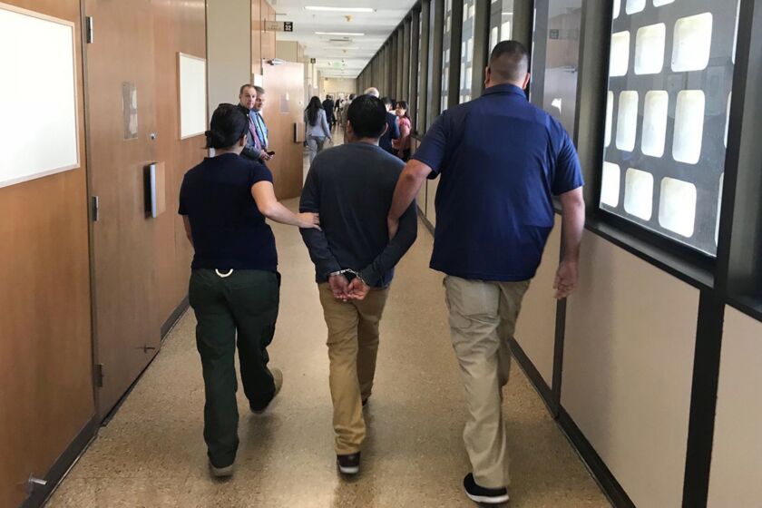 ICE agents are shown leading a suspect down the hall of Fresno County Superior Court in July 2018, prompting concerns among some attorneys over whether their clientsâ rights to due process are being violated. (Pablo Lopez / Fresno Bee)
