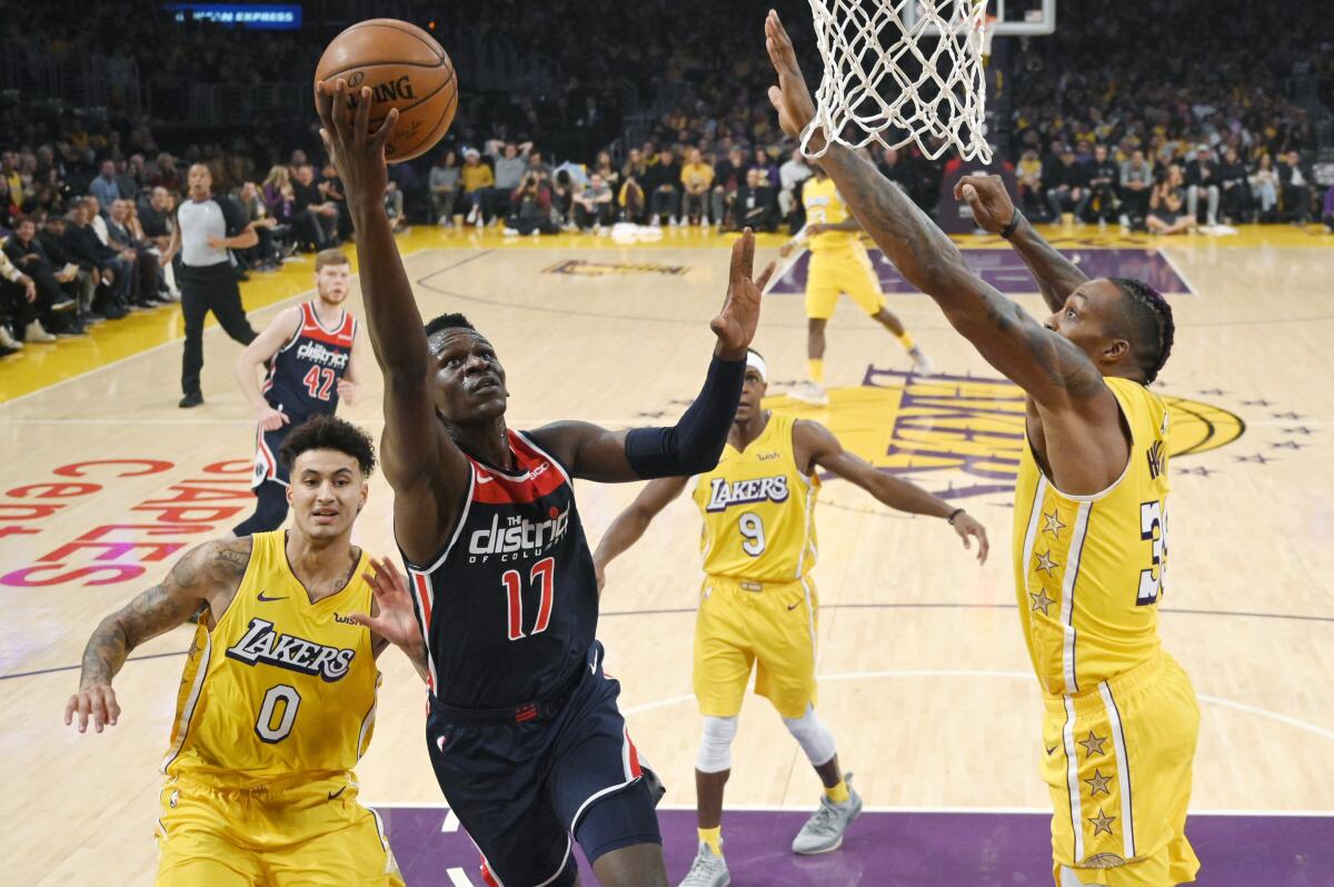 Kyle Kuzma, left, trails on the play as the Wizards' Isaac Bonga goes up for a shot Nov. 29, 2019.