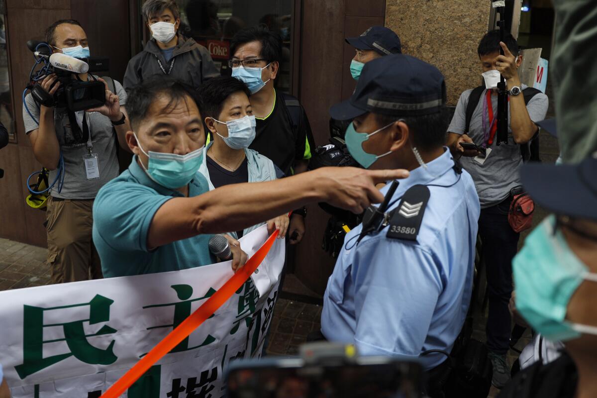 Police officers stop members of the Democratic Party during a protest Friday in Hong Kong.