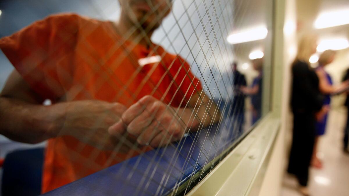 A detainee peers out from a holding area at the immigrant detention facility in Bakersfield on Thursday, April 23, 2015.