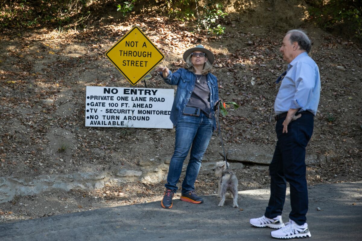Benedict Canyon residents Christina Colissimo and Robert Mann point to the area where a luxury hotel has been proposed. 