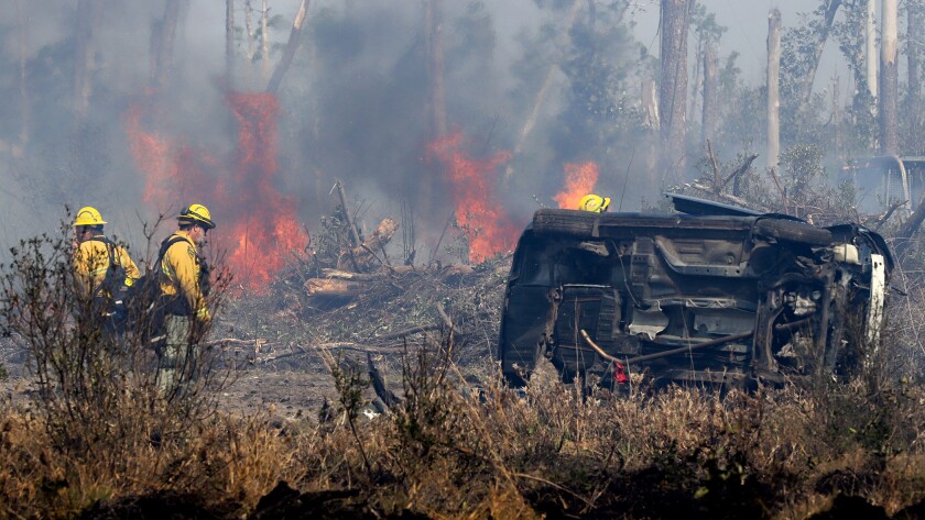 Florida Forest Service crew members wait for heavy machinery as a new hot spot flares in the Adkins Avenue Fire in Panama City, Sunday, March 6, 2022. (Michael Snyder/Northwest Florida Daily News via AP)