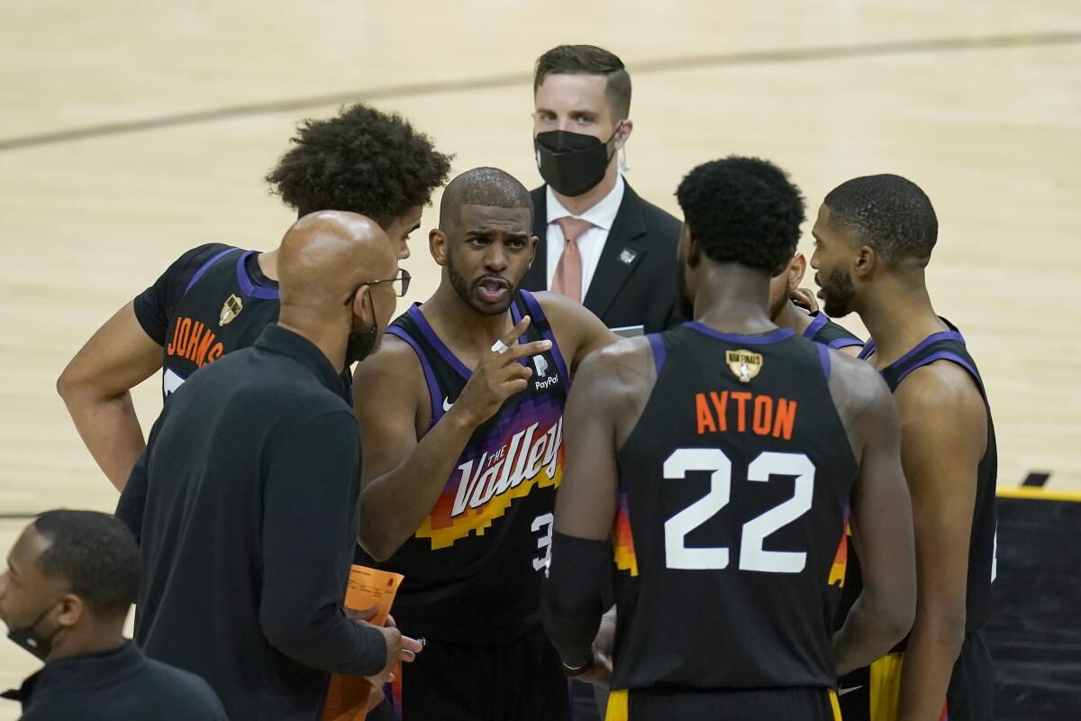 Phoenix Suns guard Chris Paul, middle, huddles with head coach Monty Williams, bottom left, center Deandre Ayton (22) and teammates during the second half of Game 5 of basketball's NBA Finals against the Milwaukee Bucks, Saturday, July 17, 2021, in Phoenix. (AP Photo/Ross D. Franklin)