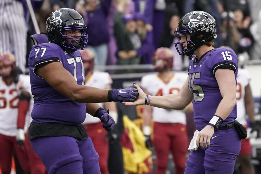 TCU quarterback Max Duggan (15) and offensive tackle Brandon Coleman (77) celebrate a touchdown during the first half of an NCAA college football game against Iowa State in Fort Worth, Texas, Saturday, Nov. 26, 2022. (AP Photo/LM Otero)