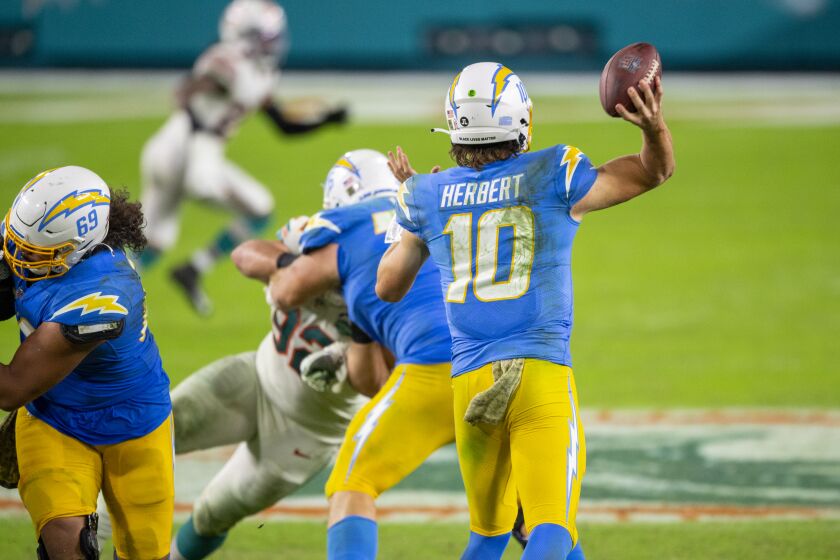 Los Angeles Chargers quarterback Justin Herbert (10) throws the ball as Los Angeles Chargers tackle Sam Tevi (69) and Los Angeles Chargers guard Forrest Lamp (76) defend against the Miami Dolphins during an NFL football game, Sunday, Nov. 15, 2020, in Miami Gardens, Fla. (AP Photo/Doug Murray)