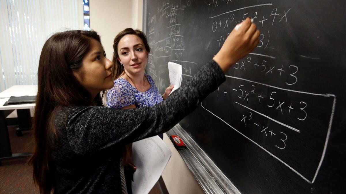 LOS ANGELES, CA-JULY 28, 2016: Jenny Mendez, 17, left, works on a pre-calculus equation, with help from teacher's assistant Samantha Sharkoff, 20, during the South Central Scholars Summer Academy-college prep program at USC on July 28, 2016. The program is designed to get high achieving students from low-income neighborhoods up to par on science, technology, engineering, and math before attending elite colleges. (Mel Melcon/Los Angeles Times)