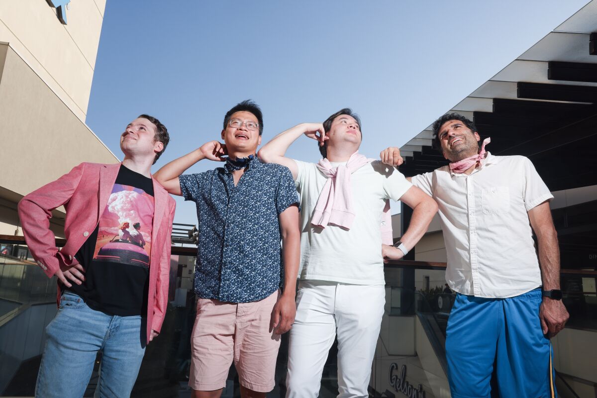 A group of four men dressed as Ken in different shorts, pants and shirts.