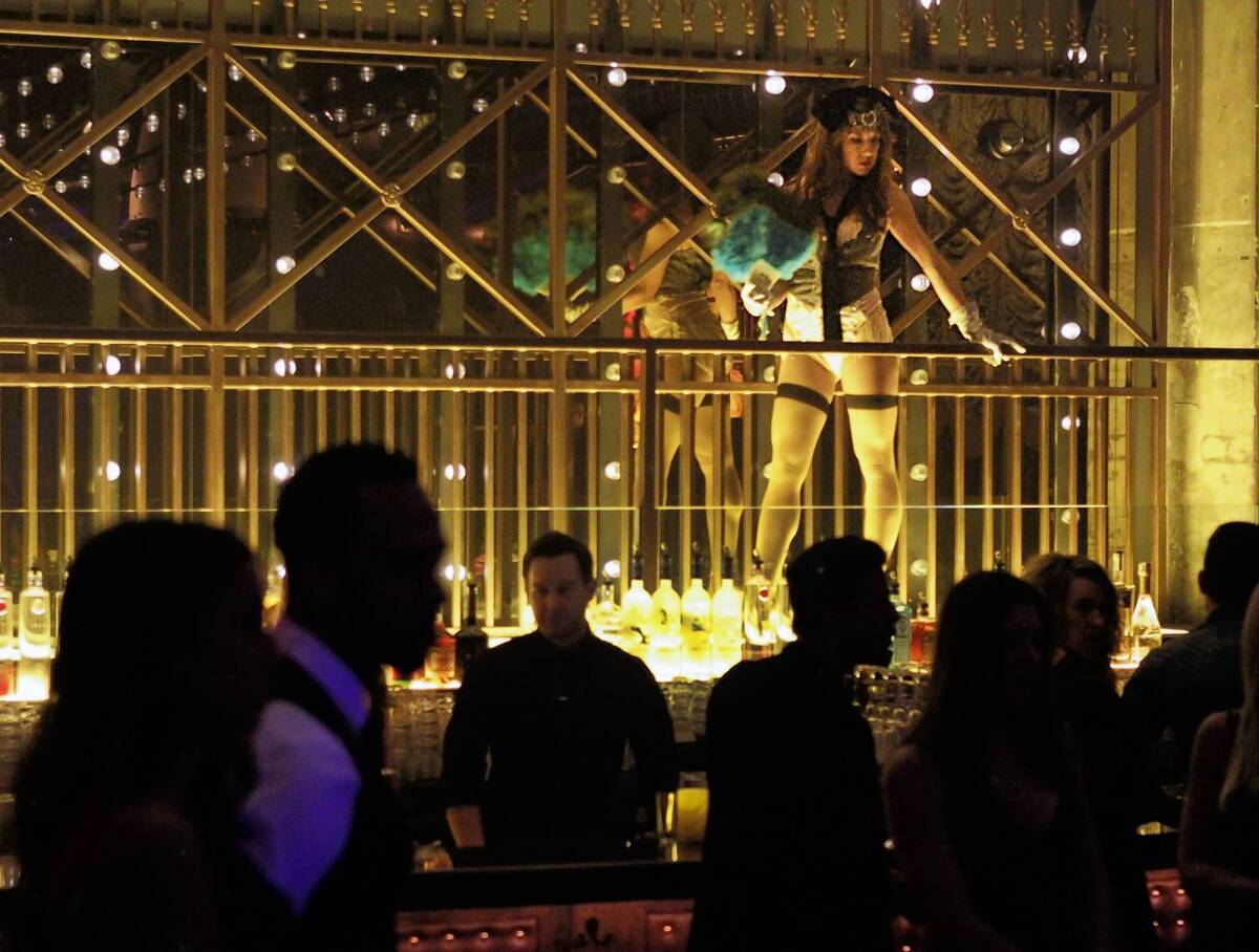 A burlesque dancer stands over the bar at the Emerson Theatre, a space designed to resemble a Prohibition-era burlesque club.