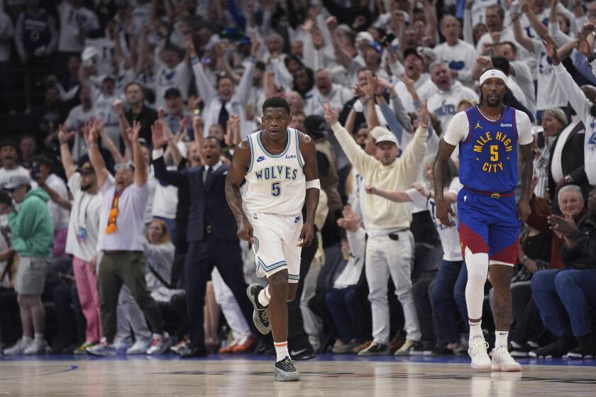Minnesota Timberwolves guard Anthony Edward, left, runs down the court after making a 3-point shot against the Denver Nuggets during the first half of Game 6 of an NBA basketball second-round playoff series Thursday, May 16, 2024, in Minneapolis. (AP Photo/Abbie Parr)