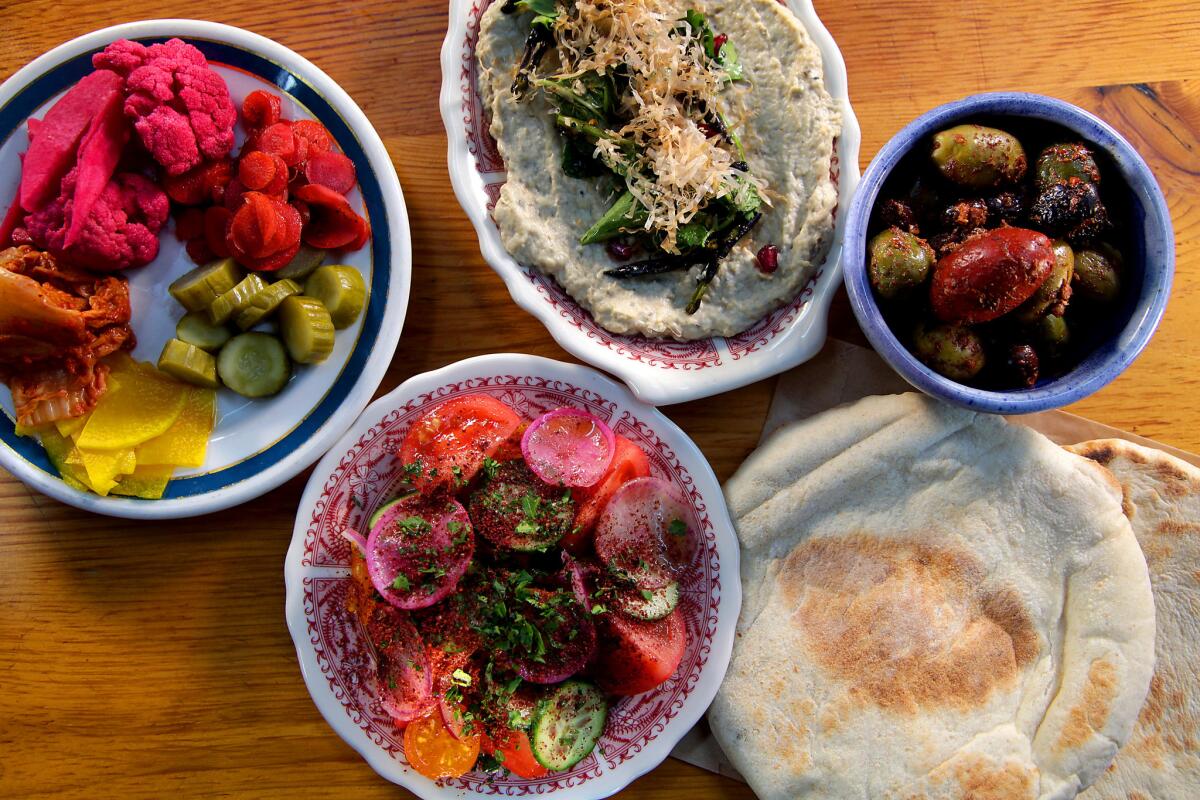 A seasonal plate of pickled and fermented vegetables, plus olives, Arabic salad, burnt eggplant and pita bread.