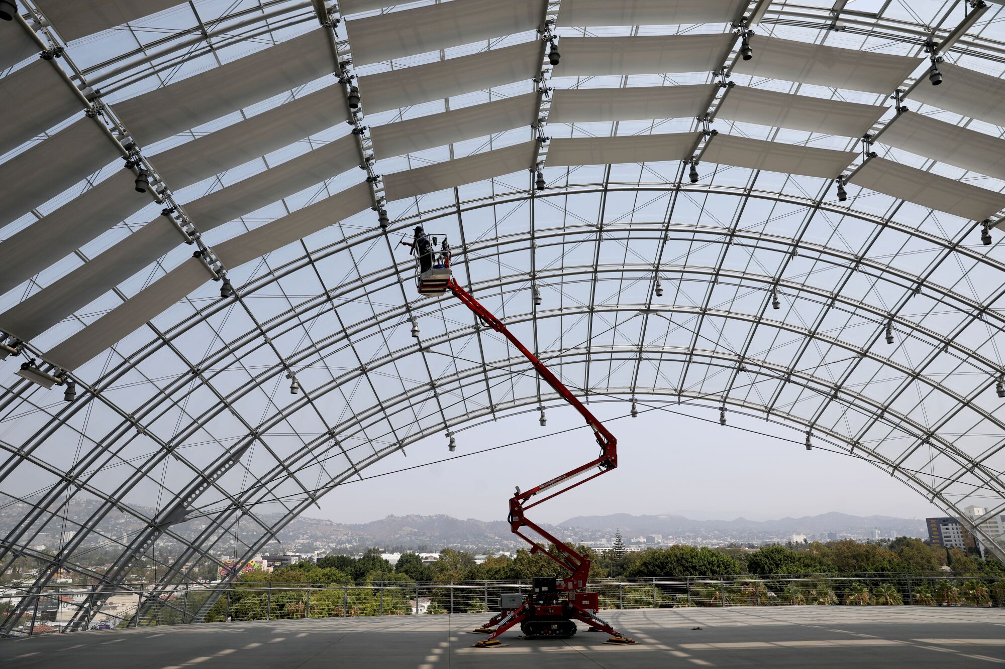  Jaime Vazquez, maintenance, cleans the glass dome covering the Dolby Family Terrace on the sphere 