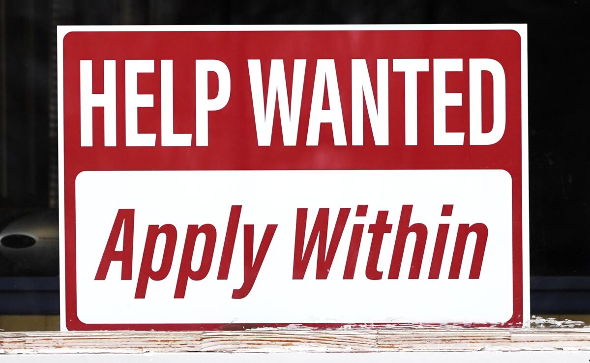 A "help wanted" sign posted in a window. 