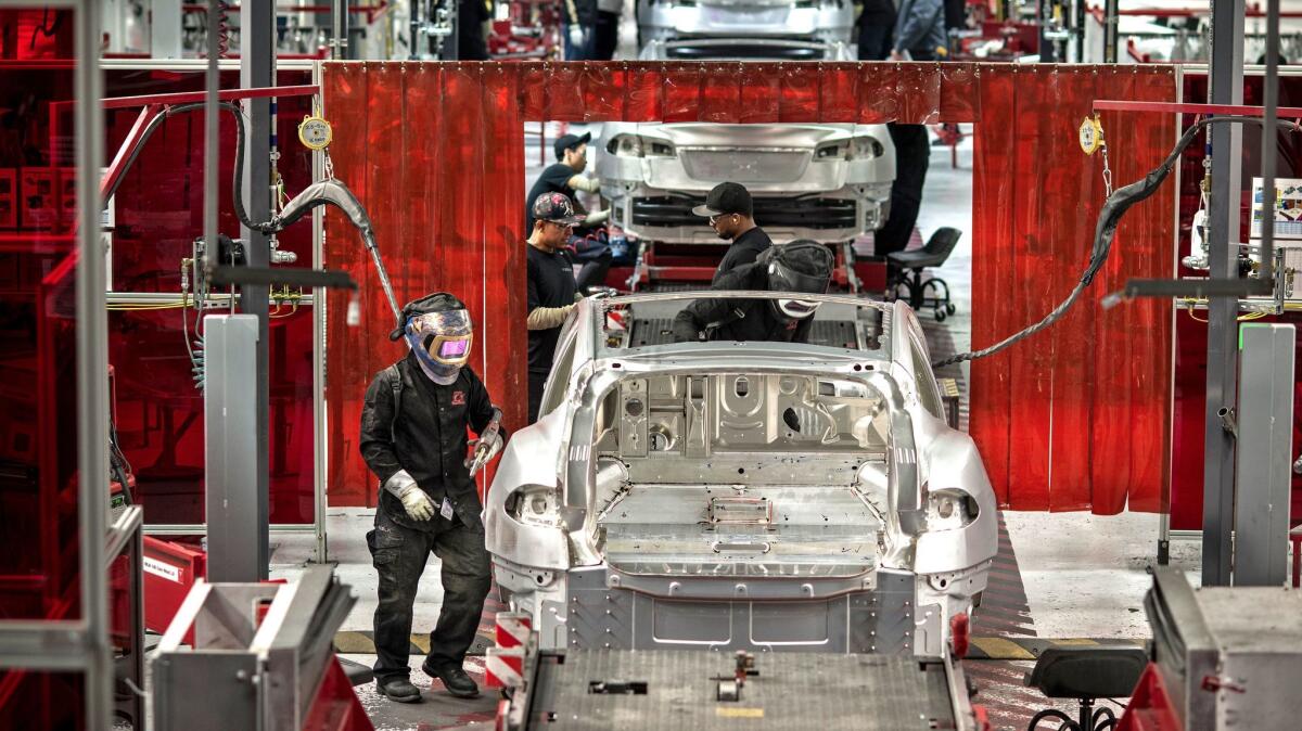 Scenes at the Tesla car factory include welders assembling various components.