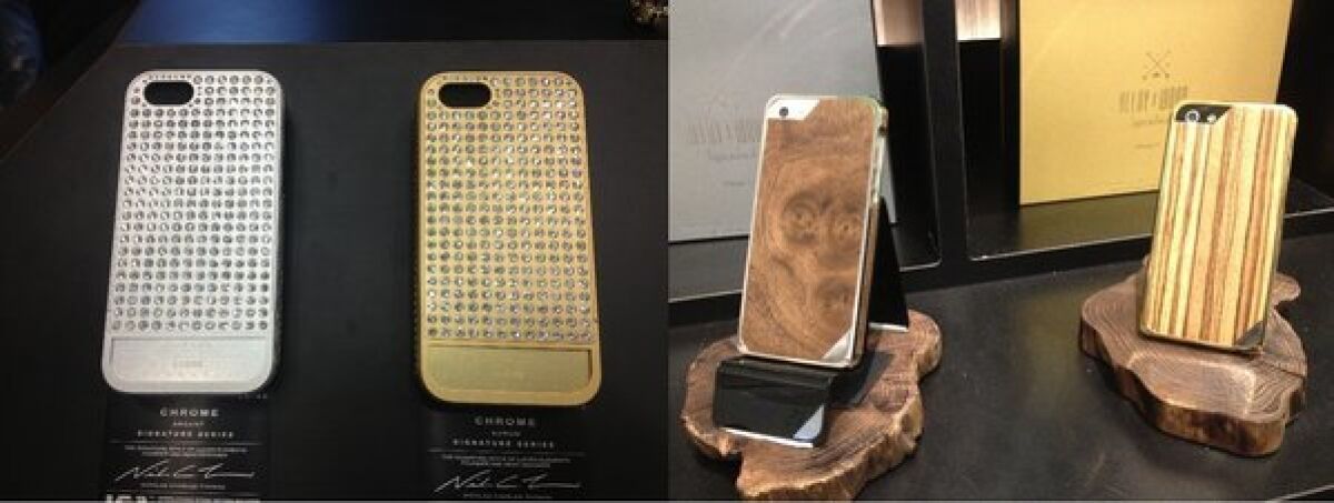 A $750 Swarovski crystal-studded iPhone case from Lucien, left, and a $300 Japanese wood and gold-plated case from Patchworks are displayed at the Consumer Electronics Show.