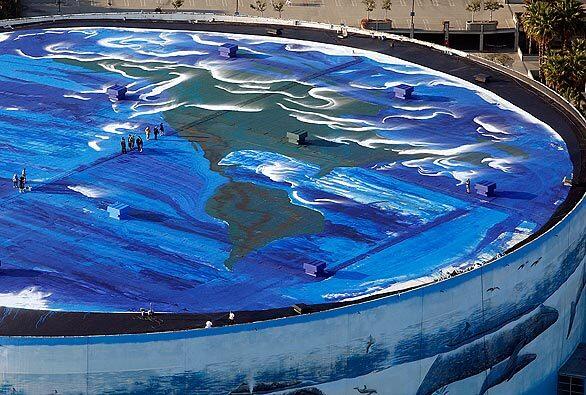 A crew led by artist Wyland puts finishing touches on his three-acre mural of planet Earth atop the Long Beach Arena as part of Earth Day celebrations. The exterior wall of the circular building features a mural of whales by Wyland.