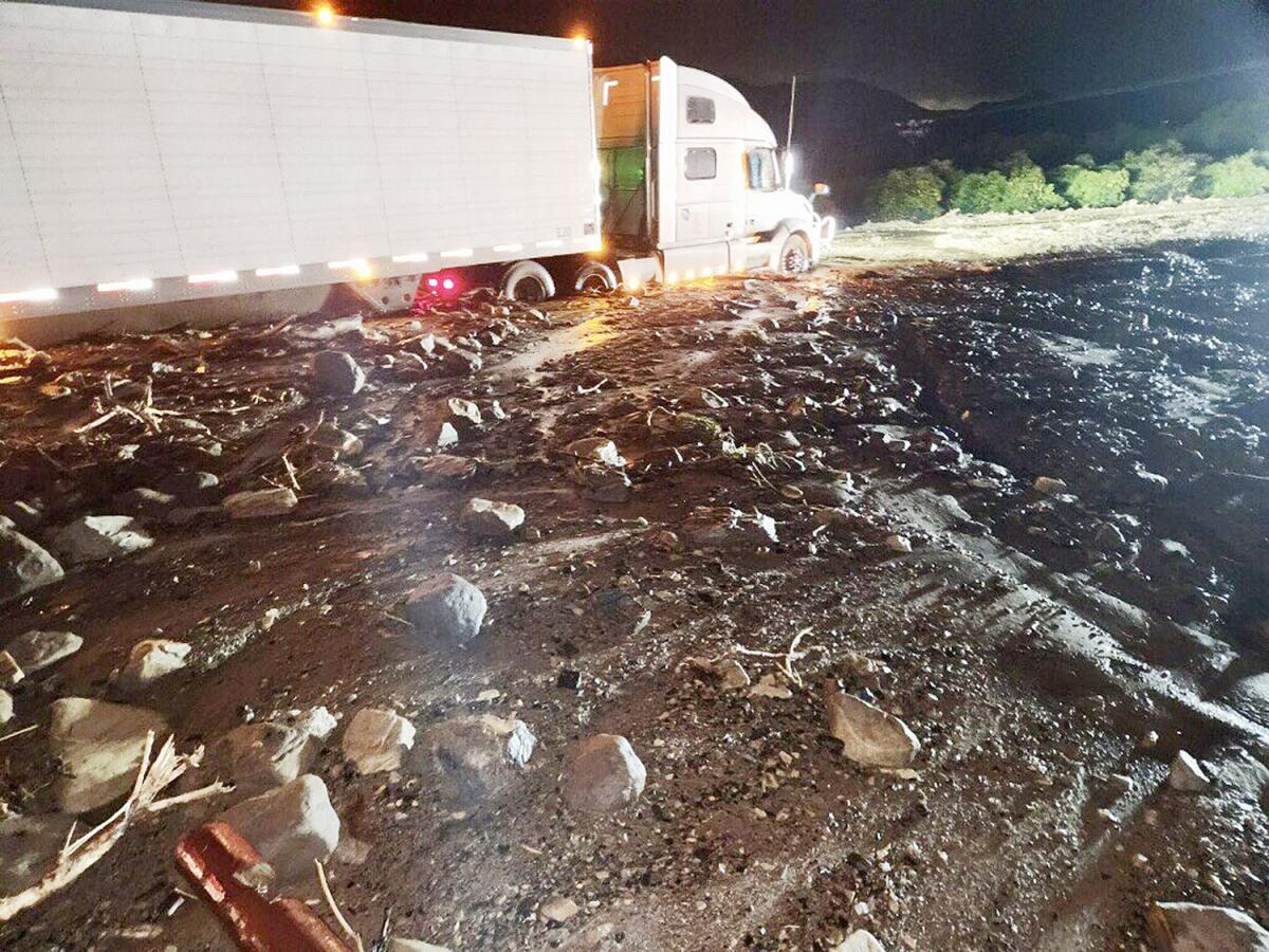 Mud and rocks surround a semi in the road