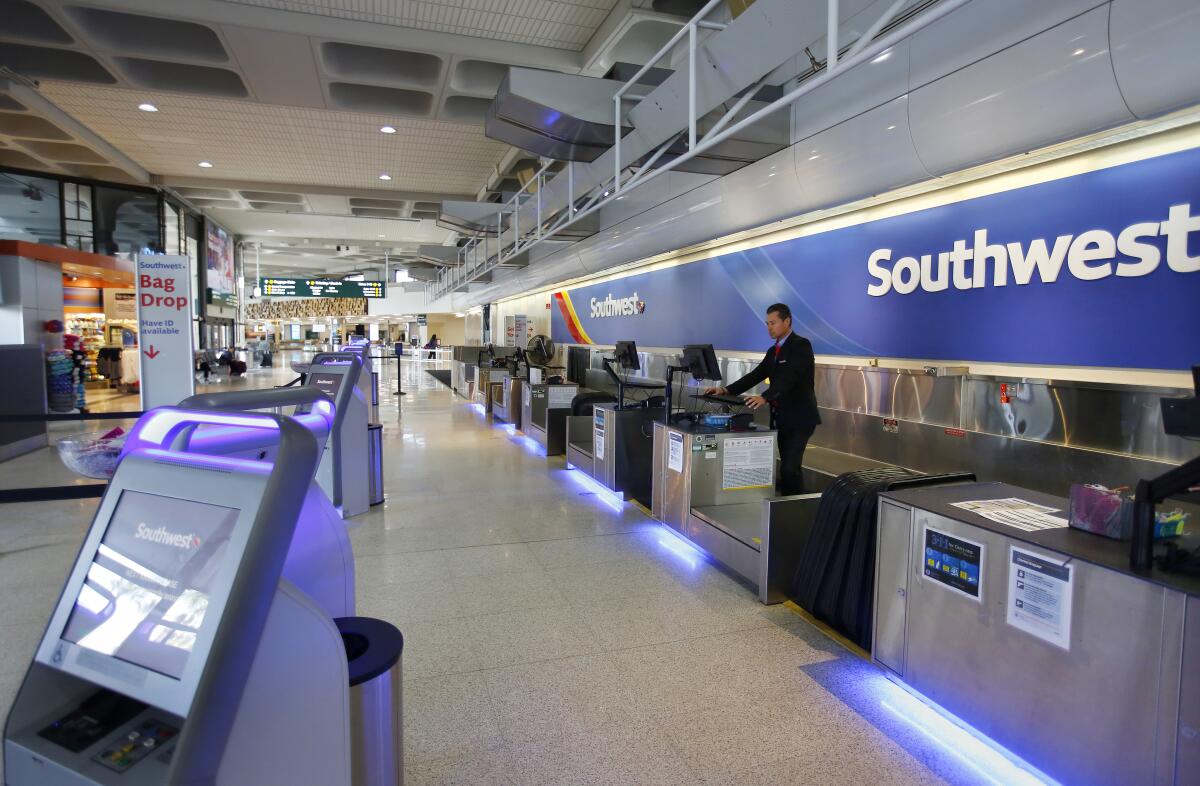 Southwest Airlines customer service agent Guillermo Rosales waits for customers at San Diego International Airport on March 24, 2020.